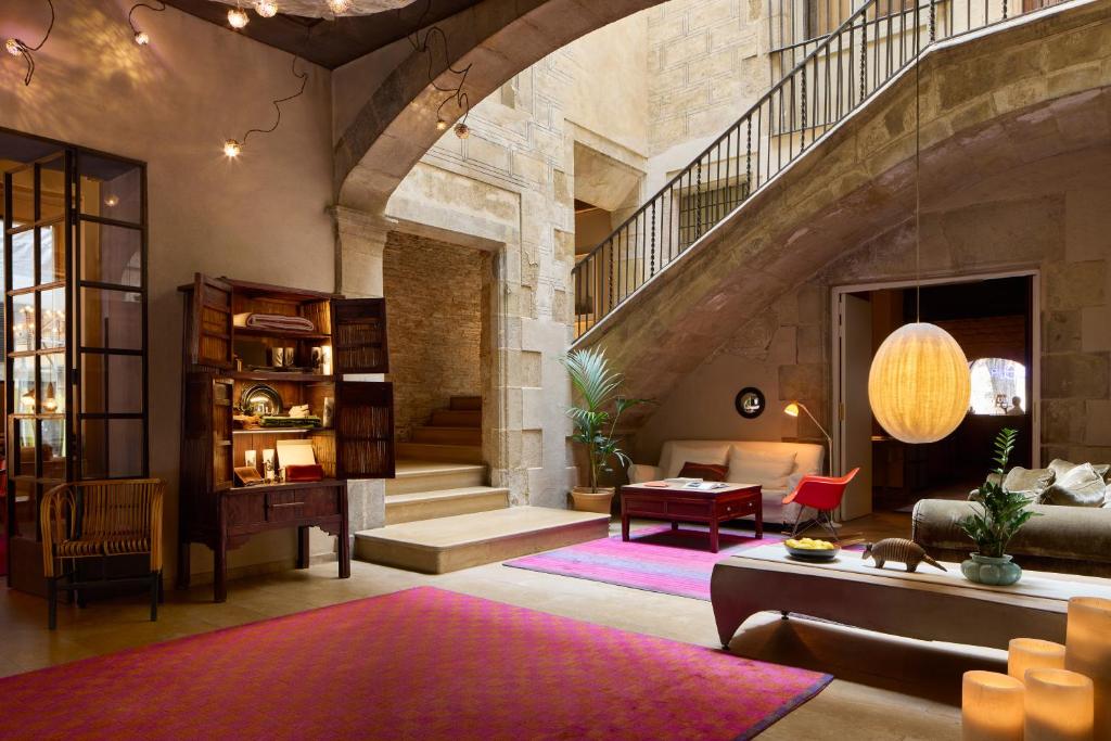 A stone lobby with an old stair, mixed furniture and a paper lantern.