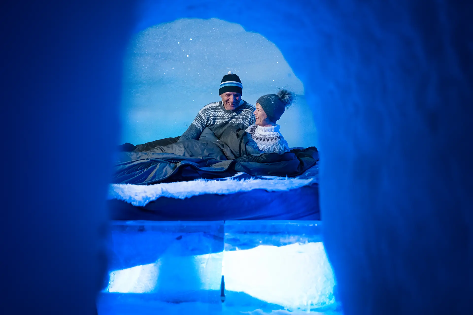 A carved snow corridor lit from within, with a doorway cut into the wall.
