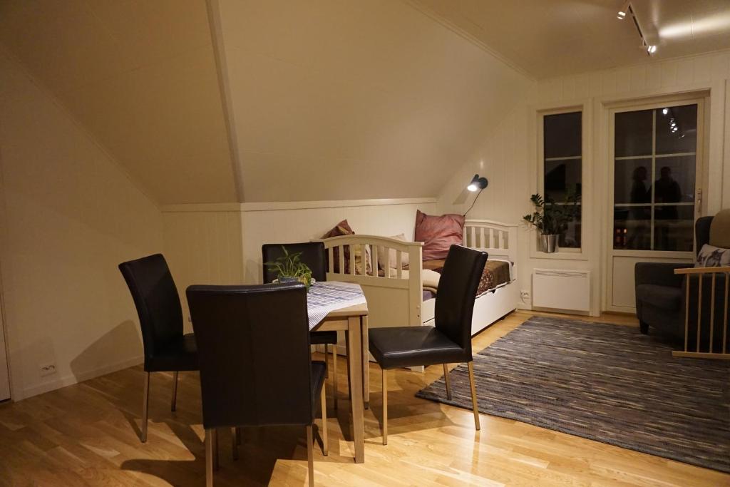 A timber-floored lodge room with a small dining table, a daybed and a sloped ceiling.